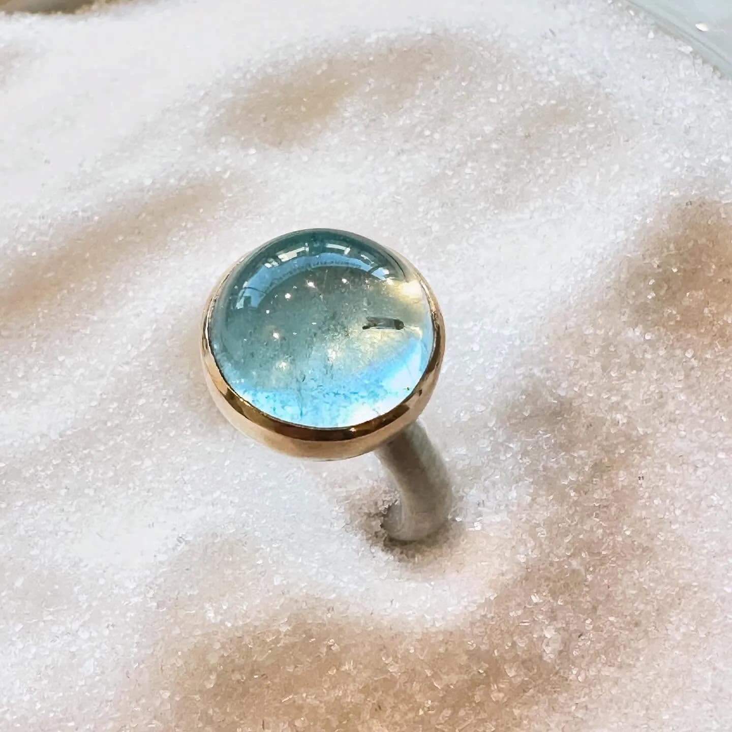 Ring mit blauem Stein und warmem Gold